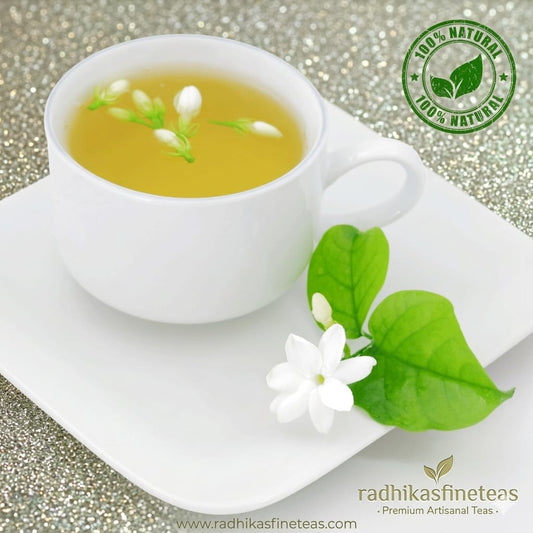 White cup of tea with jasmine flowers on a white plate, branded as Radhika's Fine Teas.