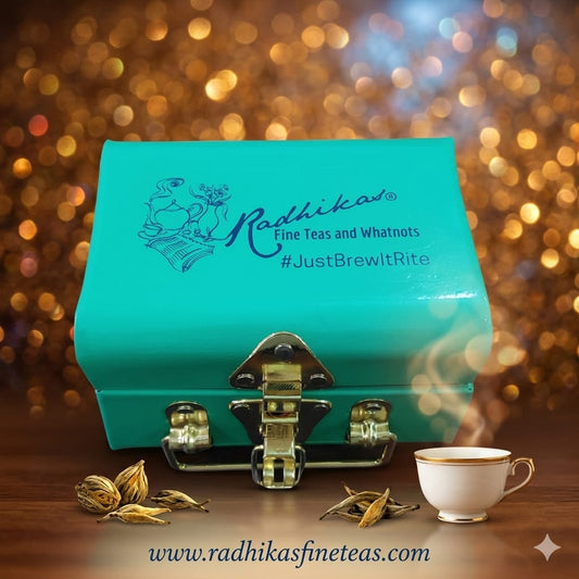 Turquoise box with Radhika's branding, tea leaves, and a steaming cup on a blurred background