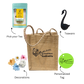 A beige jute bag branded with 'Radhikas Fine Teas' and 'Rosemary & Tea', accompanied by a green and yellow tea package, a pink flower, and a blue swan-shaped tea infuser.