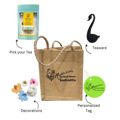 A beige jute bag branded with 'Radhikas Fine Teas' and 'Rosemary & Tea', accompanied by a green and yellow tea package, a pink flower, and a blue swan-shaped tea infuser.