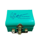 A blue metal tea trunk with the brand name 'Radhikas Fine Teas and Whatnots' and the hashtag 'Just Brew It' on the lid. It has a shiny metal clasp on the front.