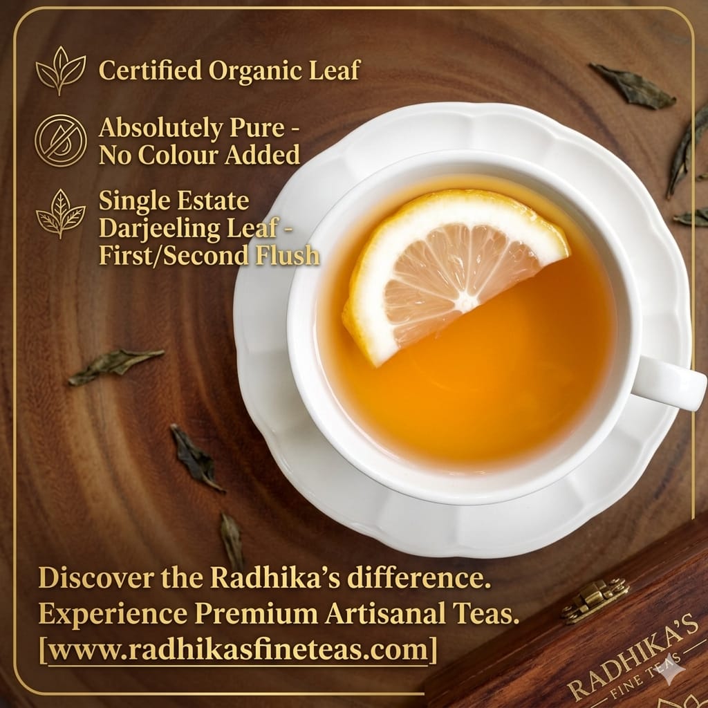 Tea cup with lemon slice on a wooden surface, featuring Radhika's Fine Teas branding.