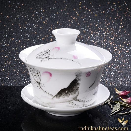 White ceramic teapot with artistic designs on a dark background