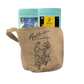 Two ziplocked pouches of Radhikas Fine Teas, one with a matcha green label and the other with a butterfly blue label, placed inside a beige jute bag with an illustration of a tea pot and leaves.