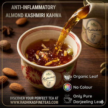 Almond Kashmiri Kahwa being poured into a cup with tea packaging and ingredients in the background.