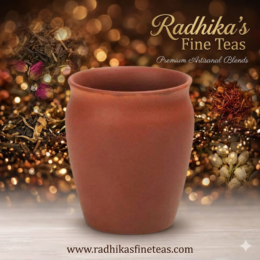 Terracotta cup with Radhika's Fine Teas branding and tea leaves in the background