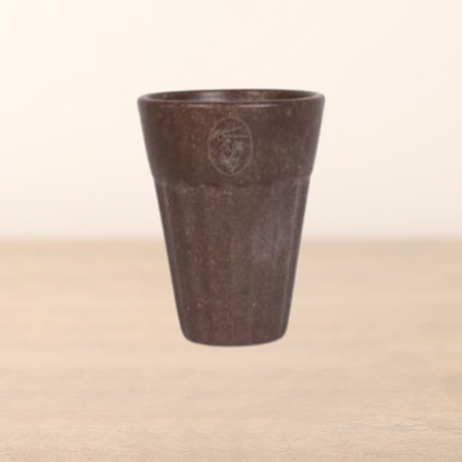 Brown ceramic cup with a logo on a beige background