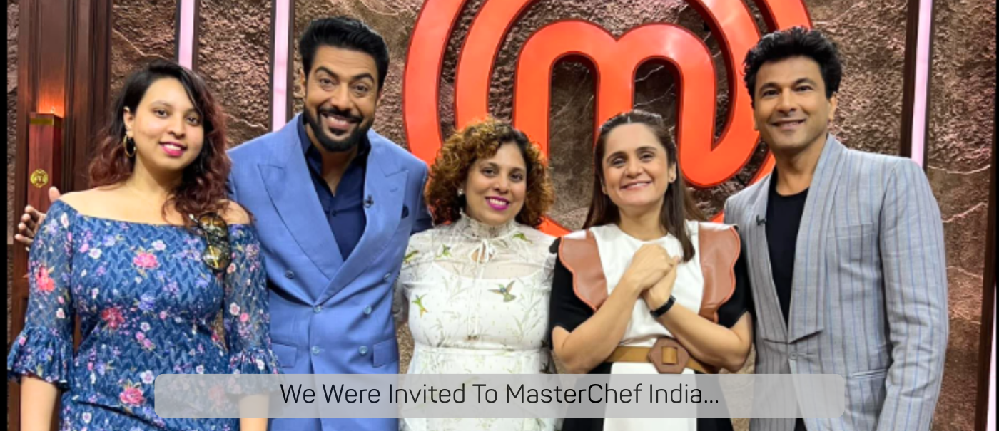 Group of people posing in front of a MasterChef India logo