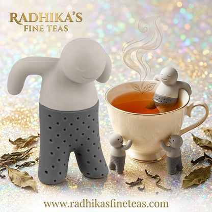 Tea infuser shaped like a person with smaller figures around a teacup, featuring Radhika's Fine Teas branding.