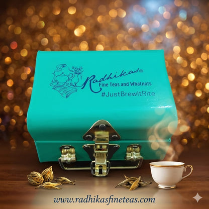 Turquoise box with Radhika's branding, tea leaves, and a steaming cup on a blurred background
